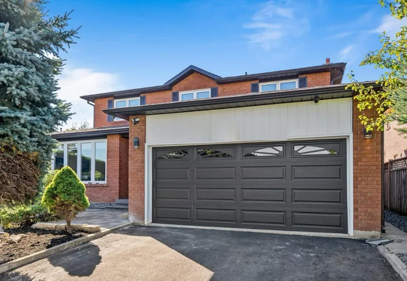 Front of a brick two-storey house with a double garage.