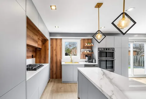 Kitchen with a marble island and pendant lights.