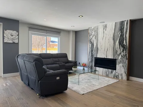 Living room with a sectional sofa and a marble feature wall.